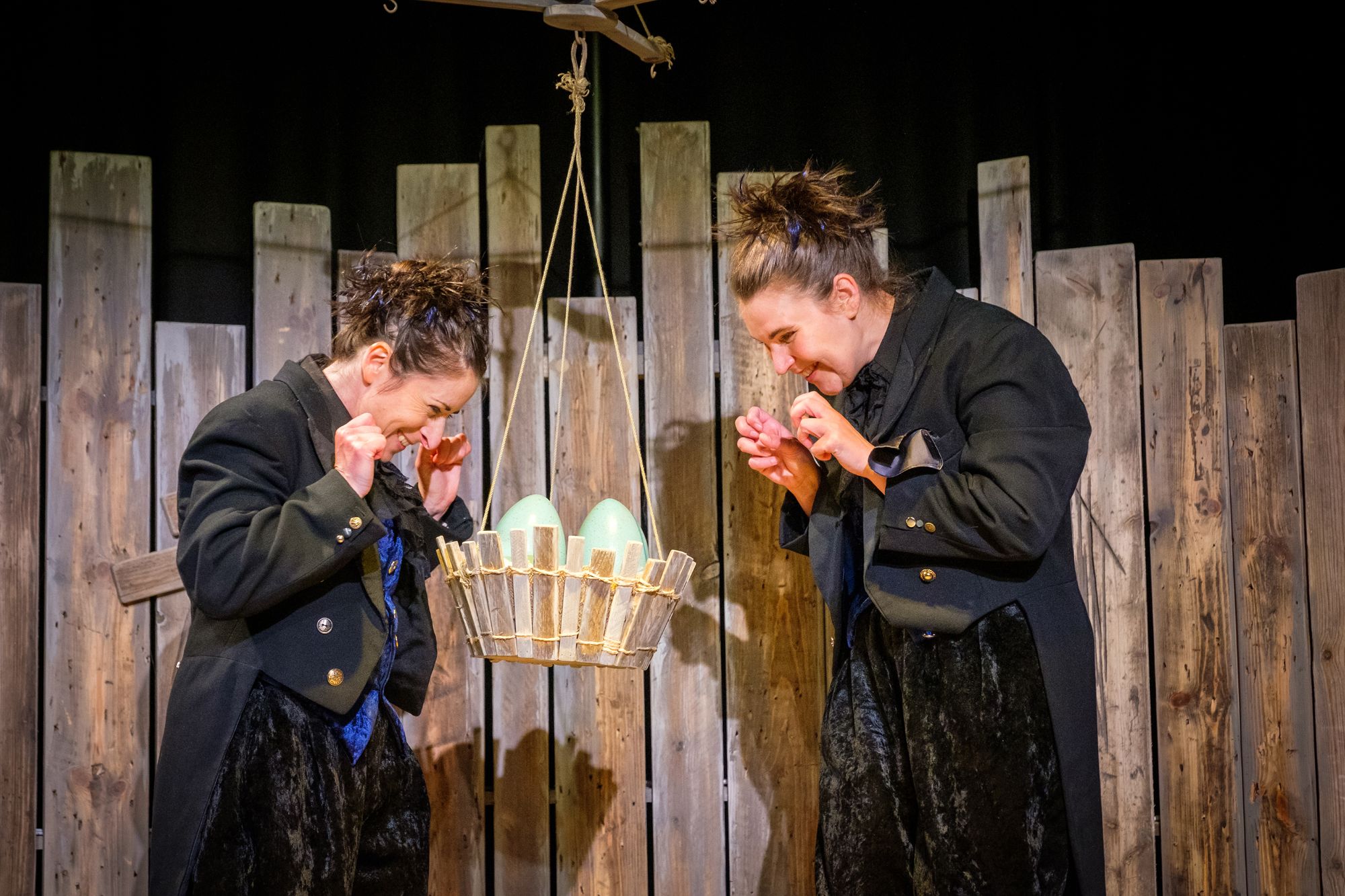 Two ladies looking down at eggs in a suspended nest