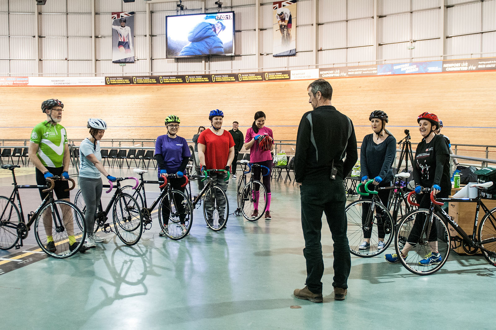 Newport Live cycling coach talking to a group of women next to the track