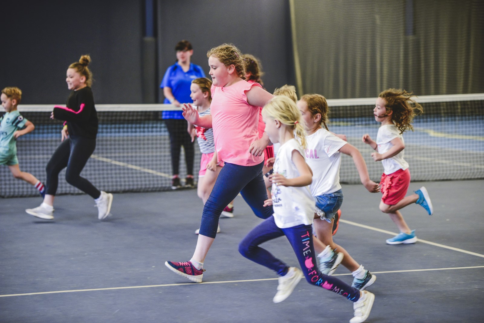 Group of children running on an indoor court.jpg