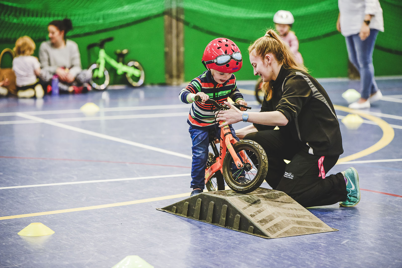 a young woman helping a young child ride a bike