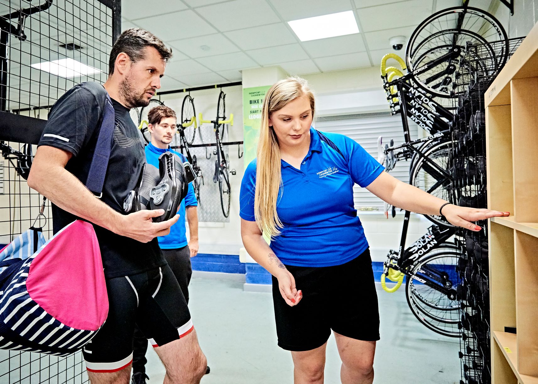 Staff member showing customer cycling shoes