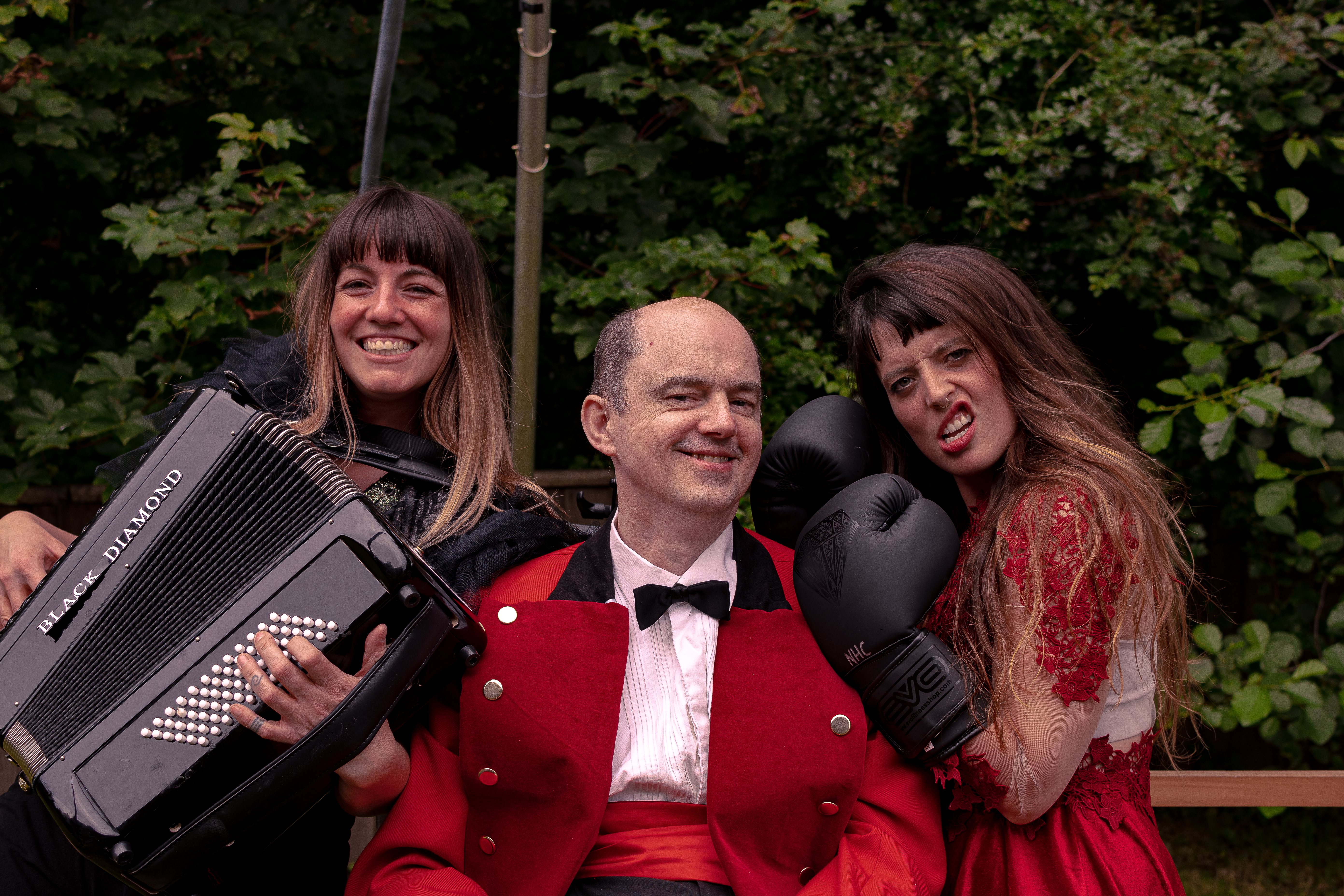 Trio of people one with accordion and one with boxing gloves