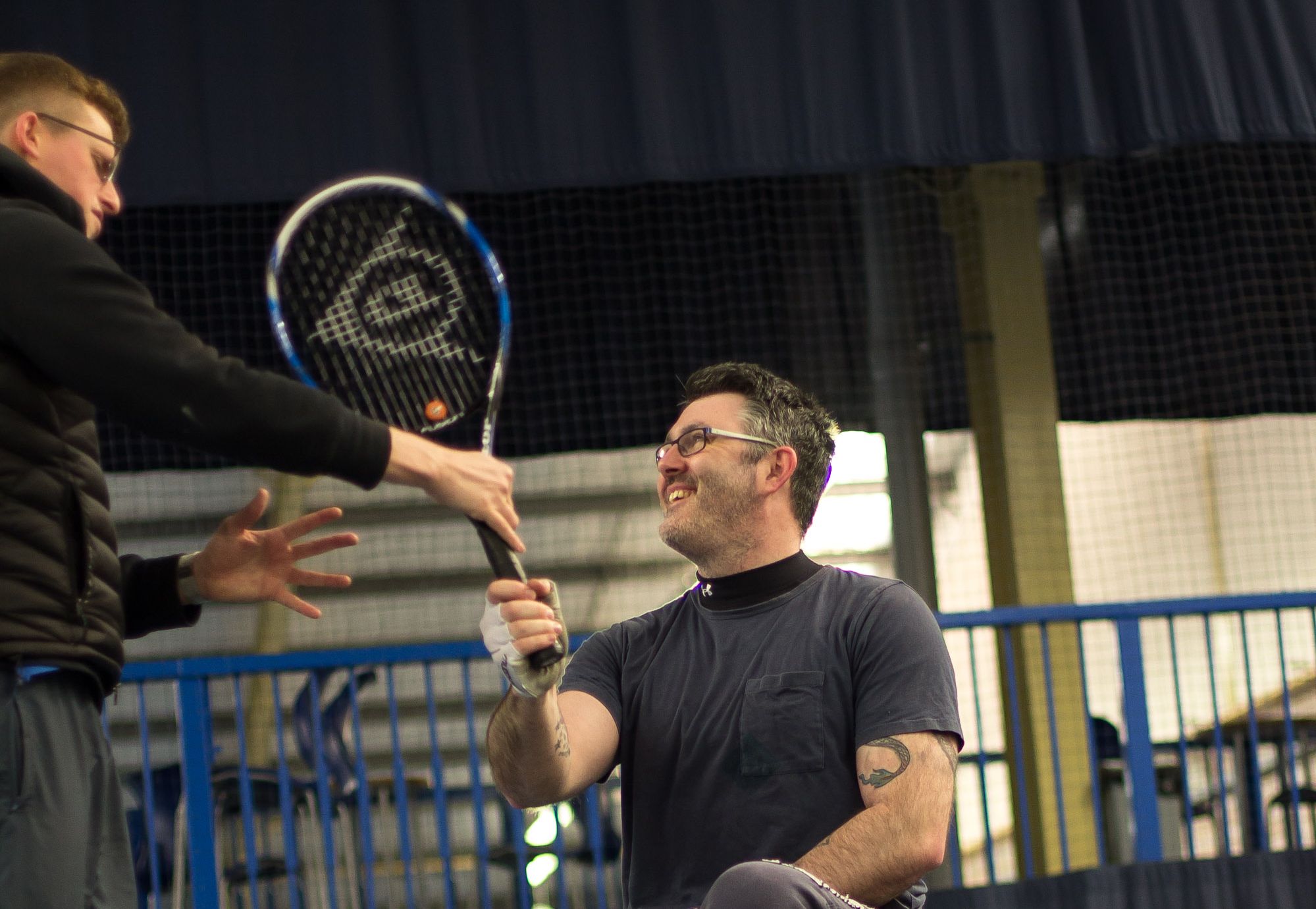 Man coaching another man in a black tshirt